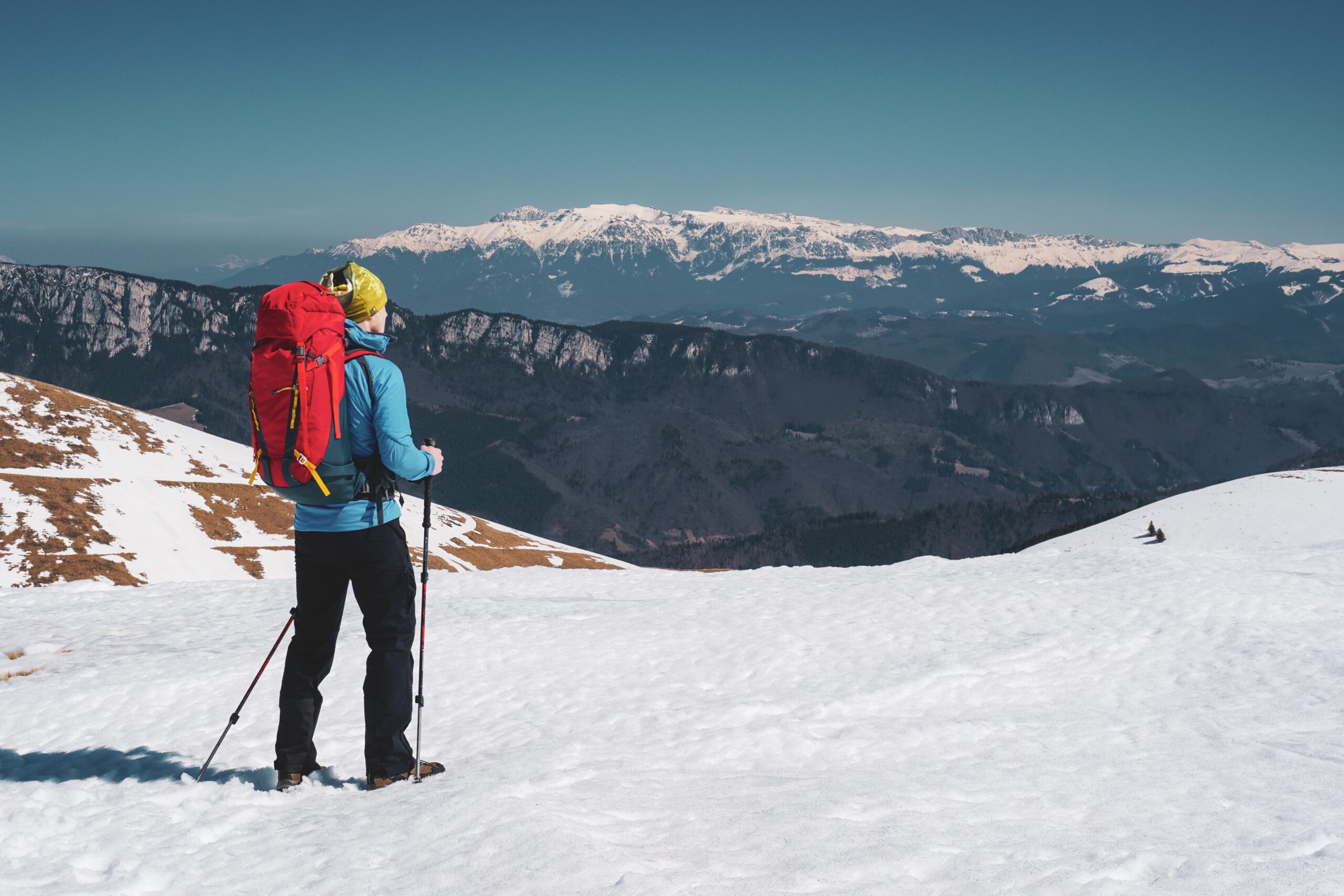 A beautiful shot of a man hiking in the snowy Carpathian Mountains in Romania